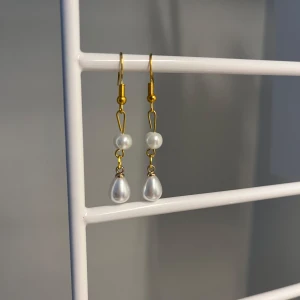 Guldiga örhängen med pärlor - Snygga örhängen med guldfärgade krokar och detaljer, dekorerade med vita pärlor i både rund och droppform. Perfekta för att ge en elegant touch till din stil. Lätta att bära och passar till många olika looks. Handgjort💕