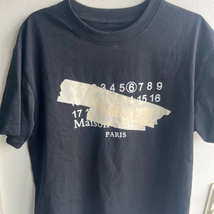 Maison margiela t shirt  - Sjukt snygg t shirt med tryck på, i storlek 46 alltså S men passar även M. Använd fåtal gånger