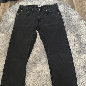 Svarta slim jeans från 157 - Svarta jeans från 157 med slim passform. Klassisk femficksmodell med knapp och dragkedja framtill. Jeansen har en stilren look och är tillverkade i ett mjukt denimtyg som sitter snyggt på benen.