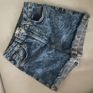 Acid wash jeansshorts från Bershka - 💙Snygga högmidjade jeansshorts från Bershka i acid wash med fransig kant nertill. Klassisk femficksmodell med gylf och knapp, samt bälteshällor. Perfekta för sommaren 