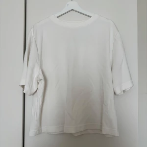 Vit t-shirt från Lager 157, storlek M - Enkel och stilren vit t-shirt från Lager 157 i storlek M. T-shirten har klassisk passform med korta ärmar och rund halsringning. Perfekt basplagg i garderoben och lätt att matcha med allt. Tillverkad i mjukt bomullsmaterial för skön känsla hela dagen.