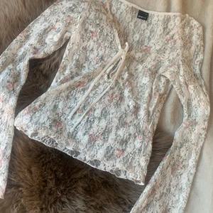 Blommig spetsblus från Gina Tricot - Romantisk blus från Gina med v urringning och utsvängda armar! Perfekt nu till sommaren!  (Aldrig använd)