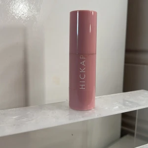 Hickap Hot Chocolate Bronzer Stick - Bronzer i stickformat från Hickap i färgen Hot Chocolate. Kommer i en snygg rosa hylsa med vitt tryck. Perfekt för contouring och bronzing, ger en varm brun ton. Enkel att applicera direkt på huden och smidigt att ta med i väskan.använd ett par gånger men väldigt mycket kvar o bra skick 