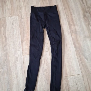 Svarta ribbade leggings 158/164 - Svarta leggings från NA i storlek 158/164. De är ribbade och har hög midja för en bekväm och snygg passform. Perfekta till både oversized hoodies och crop tops. Materialet är mjukt och stretchigt för maximal rörelsefrihet.