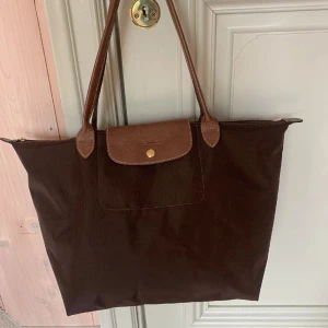 Longchamp - Brun longchamp väska som tyvärr inte kommer till användning längre. Perfekt till skola eller job då man får plats med dator och mycket mer. Några små täcken på användning. Kom gärna med frågor 🤎