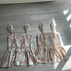 2 pack sommartröjor - Två vackra toppar med fint mönster. Går att ha både som tröja, linne, tub topp eller kjol🤍 Den beigea är aldrig använd och den vita är använd en gång.Två vackra toppar med fint mönster. Går att ha både som tröja, linne, tub topp eller kjol🤍