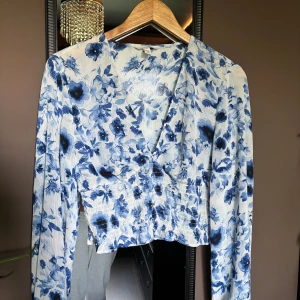 Blå blommig blus  - Säljer denna fina blåa blommiga blusen från H&M för att den tyvärr inte kommer till användning. Är andvänd några gånger och är i bra skick . Den är i st M och säljer för 60kr+frakt