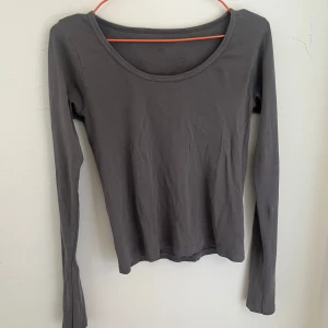 Brandy Melville longsleeve - En basic mörkgrå långärmad topp i mjuk bomull. Toppen har rund halsringning och en smal passform som sitter snyggt på kroppen. 