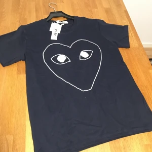 Mörkblå Comme des Garçons Play t-shirt - Säljer en mörkblå t-shirt från Comme des Garçons Play. Helt ny med tags. Storlek S. Skriv gärna vid frågor eller funderingar😊.