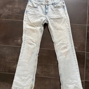 Bootcut jeans - Ljusblå jeans från Pull&Bear i rak modell med klassisk femficksdesign. Jeansen har normal passform och är tillverkade i bomull. Perfekta för dig som gillar en avslappnad och tidlös look. Low/mid waist. Strl m ev s