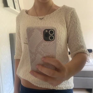 Beige stickad tröja med trekvartsärm - Säljer en beige stickad tröja med trekvartsärm och rund halsringning. Tröjan har en lite lösare passform och är perfekt för dig som gillar en enkel men snygg stil. 