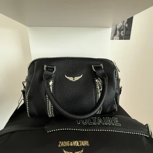 Svart handväska Zadig & Voltaire - Säljer denna snygga väskan pga flytt och måste tyvärr rensa min garderob! Original dustbag och tag medföljer såklart! Skicka gärna prisförlag💗💗 mått: 23 x 14 x 11.5 cm