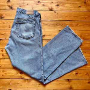 Weekday Space Relaxed Straight Jeans - Ljusblå jeans från Weekday i modellen Space Relaxed Straight. Klassisk femficksdesign, raka ben och hög midja. Tillverkade i bomull med snygg tvättad finish och kontrastsömmar. Perfekta för en chill och avslappnad look. OBS slit på högra bakficka se bild 3