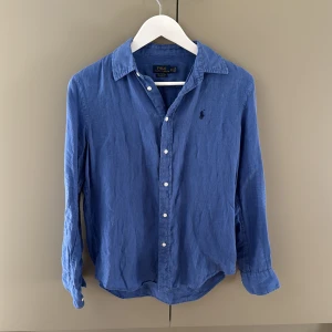 Blå linneskjorta Polo Ralph Lauren  - Snygg blå skjorta från Polo Ralph Lauren i relaxed fit. Mycket bra skick! Storlek XS passar S