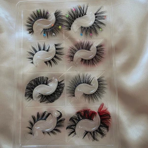 Färgglada lösögonfransar i set - Säljer ett set med åtta par lösögonfransar i olika stilar. Några har färgglada detaljer som små stjärnor och röda inslag. Perfekt för att skapa unika och kreativa sminkningar.