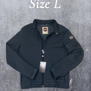 Colmar jacka - Säljer en snygg svart quiltad jacka från Colmar i storlek L / 50Jackan har en dragkedja framtill och en stilren design med långärmade ärmar. Perfekt för kyligare dagar!