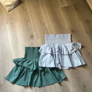 Två volangkjolar från Neo Noir - Säljer två söta volangkjolar från Neo Noir. En i ljusblå och en i grön färg, båda med elastisk midja och volanger. Perfekta för en somrig look!