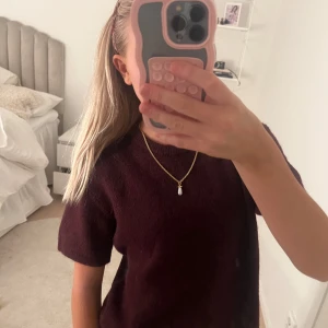 Vinröd tröja - Säljer en stilren vinröd tröja med korta ärmar. Perfekt för en avslappnad look. Tröjan har en enkel design och är lätt att matcha med olika accessoarer.