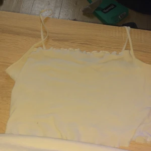 Vit ribbad linnetopp från H&M Divided - Säljer en söt vit ribbad linnetopp från H&M Divided. Toppen har smala axelband och en enkel design som passar perfekt till sommaren. Perfekt för att matcha med jeans eller kjol för en avslappnad look.