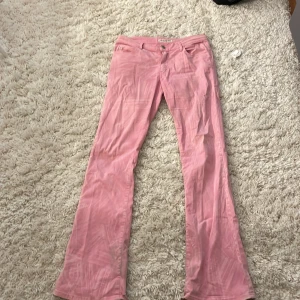 Rosa byxor från Miss Sixty - Snygga rosa byxor från Miss Sixty med en klassisk design. Byxorna har en låg midja och en bootcut-stil som ger en retro känsla. Perfekta för att lägga till en färgklick i garderoben. St S men funkar på en M också.