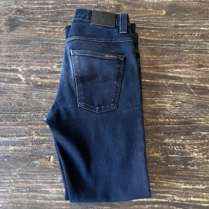 Nudie Jeans - Ett par snygga svarta jeans från Nudie! Använt relativt sparsamt och har därför inga skavanker. Det är storlek 32/32 i modellen Grim Tim. Dock uppfattar jag dem som kortare än 32! 