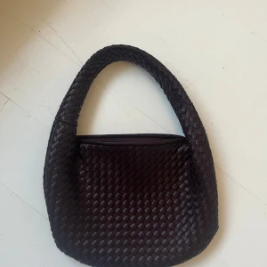 Brun / vinröd / lila  flätad axelväska - Snygg axelväska med flätat mönster. Kedjan är sönder men går att laga med blixtlås