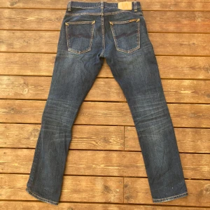 Blå jeans från Nudie Jeans Co - Säljer nu mina skitsnygga nudie jeans grimtim i färgen Ink Navy. Skick 9/10 förutom att de har en lagning i skrevet. Hör av er om ni har frågor, de passar någon som är runt 180