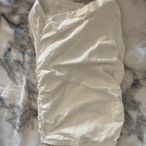 Vit omlottklänning - Säljer en stilren vit omlottklänning med en elegant drapering. Perfekt för sommarens alla tillfällen. Klänningen har en v-ringad design och är tillverkad i ett mjukt material som ger en skön passform. (Bilden är uppochner så den ser inte ut så hahah)