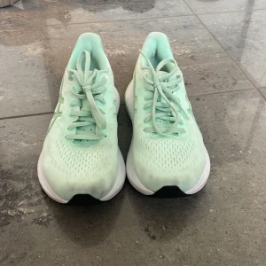 Mintgröna sneakers från Asics - Säljer ett par fräscha mintgröna sneakers från Asics. Skorna har en luftig ovandel med snörning och en vit sula med svart mönster undertill. Perfekta för träning eller en aktiv vardag. Skriv privat frågor eller annat, pris kan snackas.😃