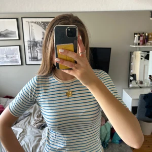 Randig t-shirt från Zara - Säljer en snygg randig t-shirt från Zara i beige/vit och blått. Använd ett fåtal gånger så i bra skick!