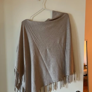 Beige poncho från Jake's - beige  poncho från Jake's med fransar i kanterna. Använd fåtal gånger 