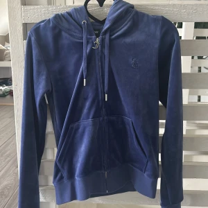 Blå hoodie från Juicy Couture - Säljer en snygg blå hoodie från Juicy Couture. Tröjan är knappt använd och har därför inga defekter. 