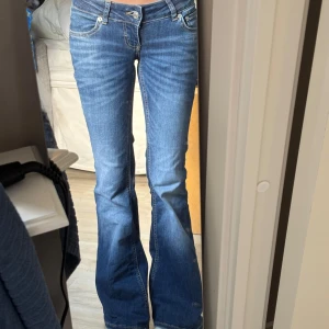 Blå bootcut jeans med låg midja - Säljer ett par snygga blå jeans med bootcut-modell och väldigt låg midja. Jag är ungefär 160 och tycker dem är lite för långa men det funkar ändå 💕använda 2 gånger 