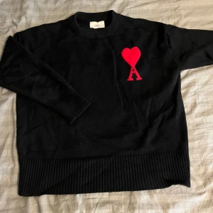 Svart stickad tröja från Ami Paris - Tjena säljer denna ami Paris Hoodie i mycket bra skick bara använts cirka 10 gånger hör av vid intresse.