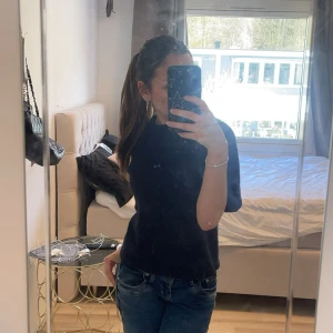 Mörkblå stickad kortärmad tröja - Mysig mörkblå stickad tröja med korta ärmar och rund hals. Perfekt att styla med jeans eller kjol för en chill och enkel look. Tröjan har en rak passform och är gjord i ett mjukt stickat material som känns skönt mot huden.