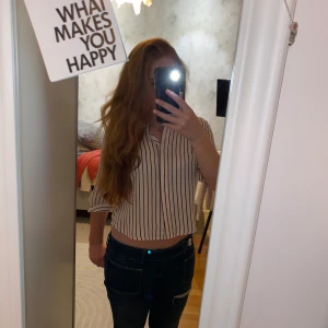 Ljus rosa randig skjorta från Monki - Säljer en ljus rosa skjorta från Monki med svarta vertikala ränder. Skjortan har krage, knappar framtill och trekvartsärmar som kan vikas upp. Den är i ett lätt och mjukt material, perfekt för en chill och stilren känsla.