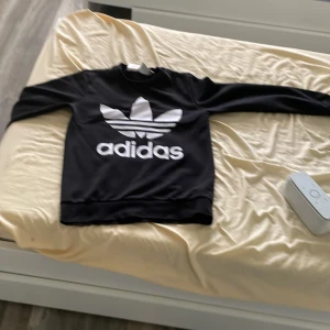 Svart Adidas sweatshirt med logga - Har en Gammal adidas tröja som jag använde, bra för vintern och för en extra tröja om det är lite kyligt. Denna är helt ny, knappt använd men fortfarande gammal eftersom att jag hade tappat bort den någonstans i huset LOL. Passar bra för 12-15 åring beroende på längd och sånt STORLEK 160