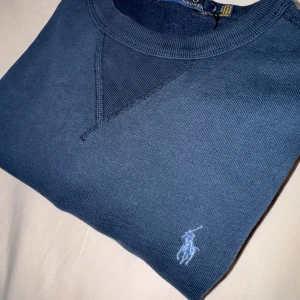 Marinblå raulph lauren sweatshirt  - Helt ny sweatshirt, inga defekter alls. Nypris 2000kr. Storlek S men passar M vid vissa fall. MÅTT: axelbredd=42cm och längd=55cm. Pris går att diskuteras vid snabb affär. Såklart äkta. 