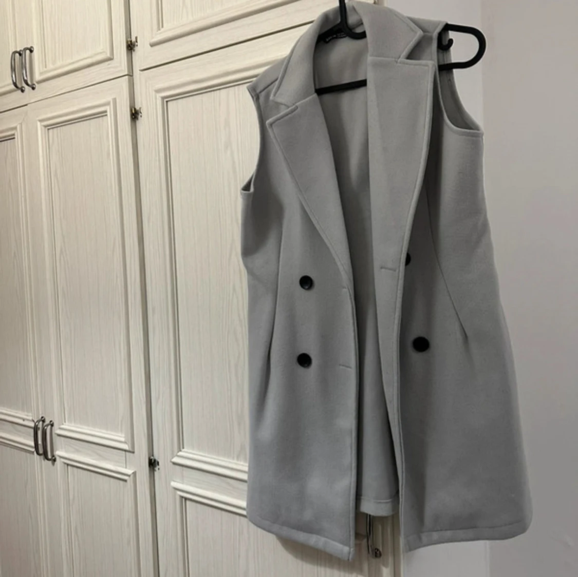 Ljusgrå lång väst med knappar