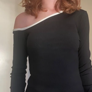 Svart offshoulder topp från NA-KD - Svart ribbad offshoulder topp från NA-KD i storlek S. Fick den av en släkting men har aldrig använt så jag säljer den nu🥰