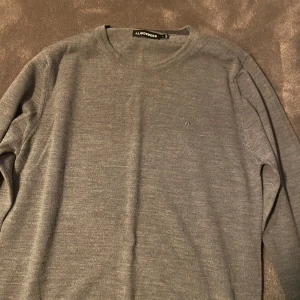 Grå merinoull tröja från J.Lindeberg - Snygg grå stickad tröja från J.Lindeberg i storlek S. Tröjan har rund hals och diskret logga på bröstet. Knappt använd pga för liten, 9/10 skick, nypris 1000 kr