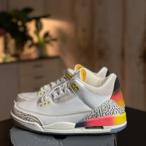 Nike Air Jordan 3 i vitt och gult - Nike Air Jordan 3 sneakers med vit ovandel i skinn, detaljer i gult och rött samt klassiskt elephant print-mönster. Sulan har inslag av rött och gult, och skon har snörning och rund tå. Perfekt för dig som vill sticka ut med en färgstark och ikonisk sneaker.