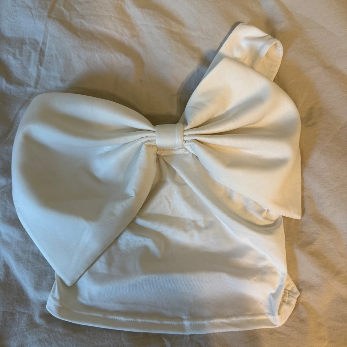 Vit axelbandslös topp med stor rosett