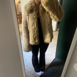 Beige pälsjacka från  - Säljer en fluffig och oversized beige pälsjacka. Jackan har bred krage, långa ärmar och är tillverkad i mjukt fuskpälsmaterial. Perfekt för dig som vill sticka ut och hålla dig varm under kalla dagar.