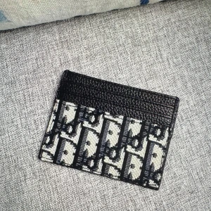 Plånbok i svart och beige - Snygg korthållare med klassiskt monogrammönster i svart och beige. Övre delen är i svart skinn med flera kortfack och nedre delen har Diors ikoniska tryck. Perfekt för dig som vill ha en stilren och lyxig accessoar i fickan.