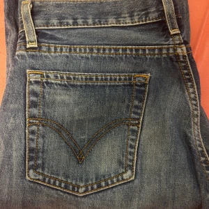  Vintage Levi's 501 blå jeans straight fit - Vintage Levis jeans, fick dem av min mamma men har inte använt dem, eftersom att de är lite för små.Klassiska Levi's 501 jeans i mellanblå tvätt med snyggt slitna detaljer. Rak passform, femficksmodell och ikonisk röd Levi's-tag på bakfickan. Tjockt jeanstyg i bomull och tydliga kontrastsömmar. Perfekta för en avslappnad och tidlös stil. Storlek 36/34