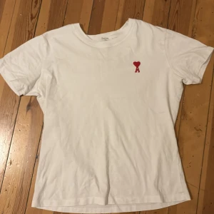 Vit t-shirt från Ami med rött hjärta - Vit t-shirt från Ami Alexandre Mattiussi i storlek L. Klassisk rund hals och korta ärmar. På bröstet finns ett broderat rött hjärta. Det är en L men på mig som har L vanligtvis är den liten. 