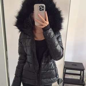Svart pufferjacka med fuskpäls från Zara - Svart pufferjacka från zara me fluff huve som går ta bort ocksp, måttligt använd❤️