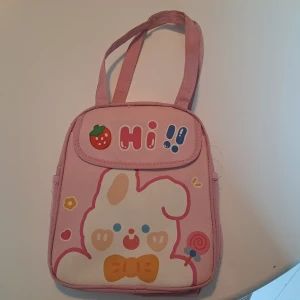 Gullig rosa kylväska - Supergullig rosa kylväska med uttre ficka och två sido fickor! Här användas och har tyvärr fläckar (se på bild) Funkar bra och håller mat kalt! Får plats med mycket.