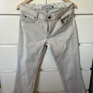 Ljusgrå jeans - Snygga ljusgrå jeansbyxor i klassisk femficksmodell. Byxorna har raka ben, tydliga kontrastsömmar och dragkedja i gylfen. Perfekta för dig som gillar en clean och stilren look.